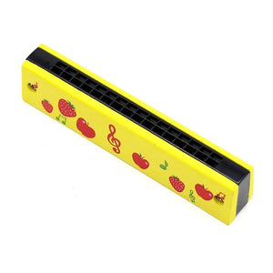 Yellow wooden harmonica with fruits on a white background