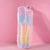 Yellow toddler utensils in a travel case on pink background