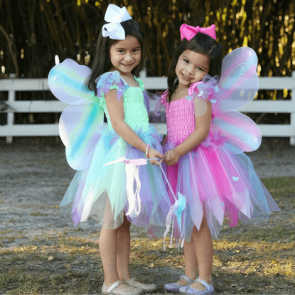 Two girls wearing butterfly dress up costumes with wings and wands