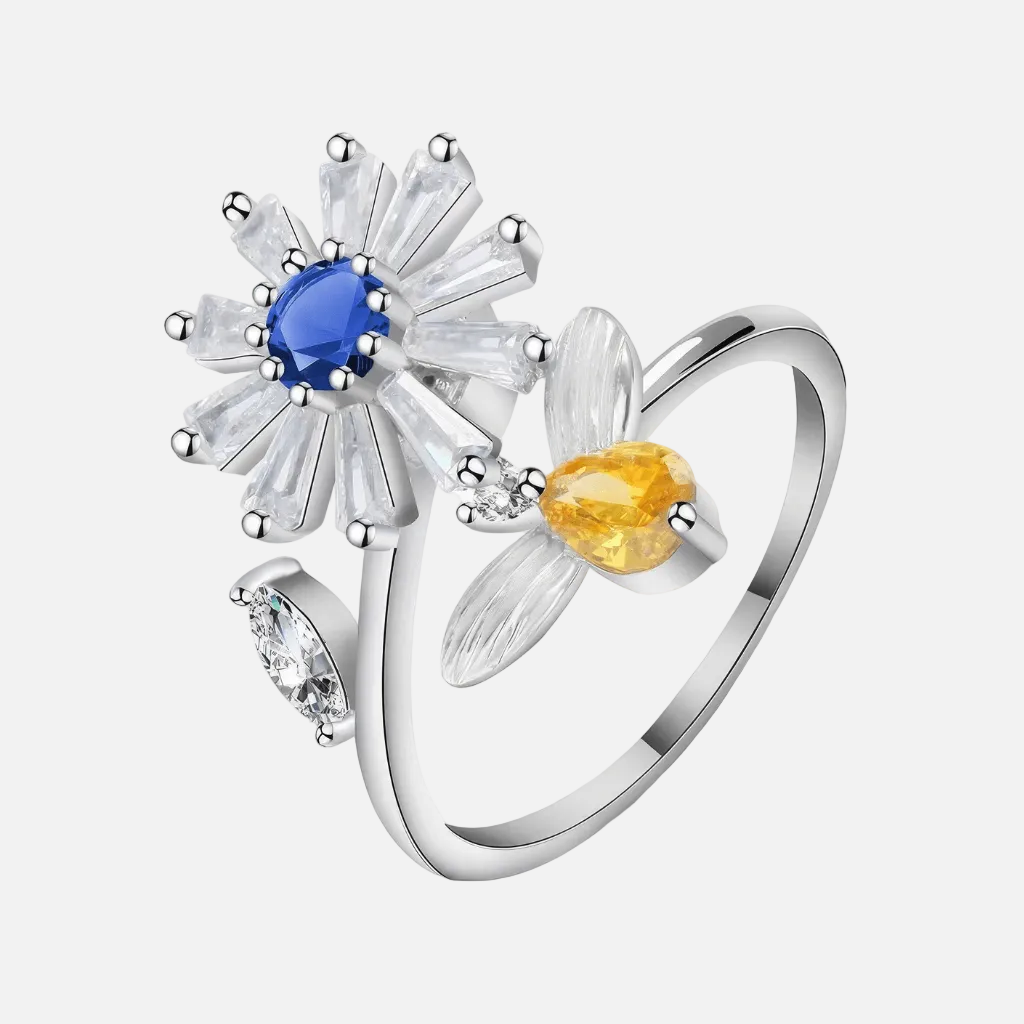 Rhodium plated 925 silver daisy spinner fidget ring with blue and amber cubic zirconia on white background