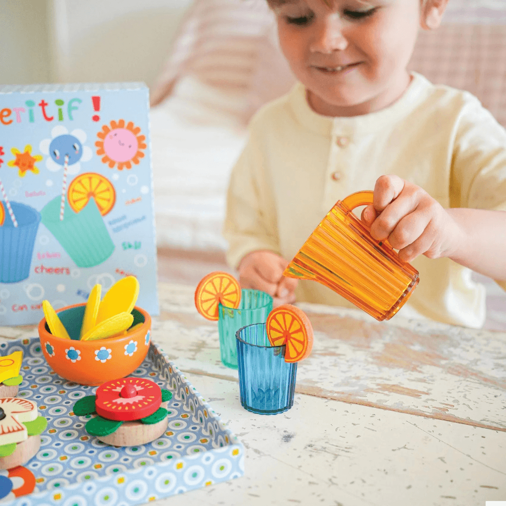 Child pouring drinks with Djeco Mia and Leo appetizer role play set developing social and motor skills