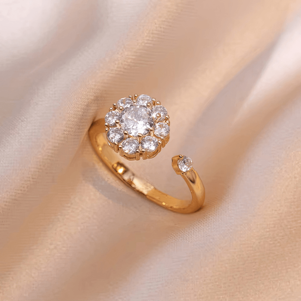Gold plated adjustable flower fidget ring with cubic zirconia on cream fabric