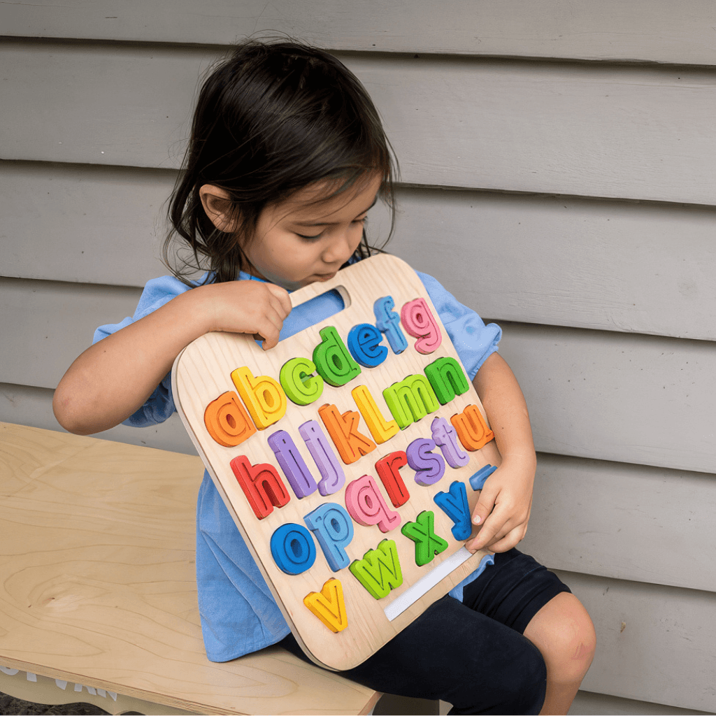 Child holding Kiddie Connect lowercase alphabet puzzle with handle for portable learning