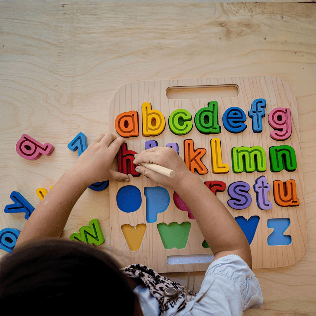 Top view of Kiddie Connect wooden lowercase alphabet puzzle with colourful letters and tracing stylus