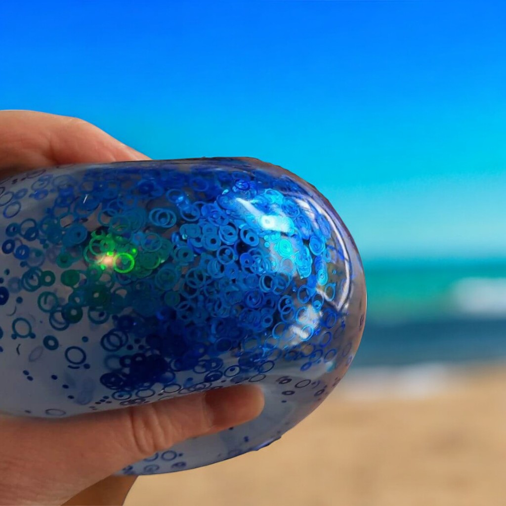 Sequin squishy ball on beach background