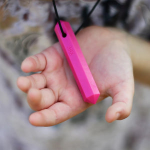 Child hand holding Ark's krypto bite chew necklace Australia in pink