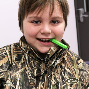 Boy chewing on Ark's krypto bite chew necklace for boys in lime green