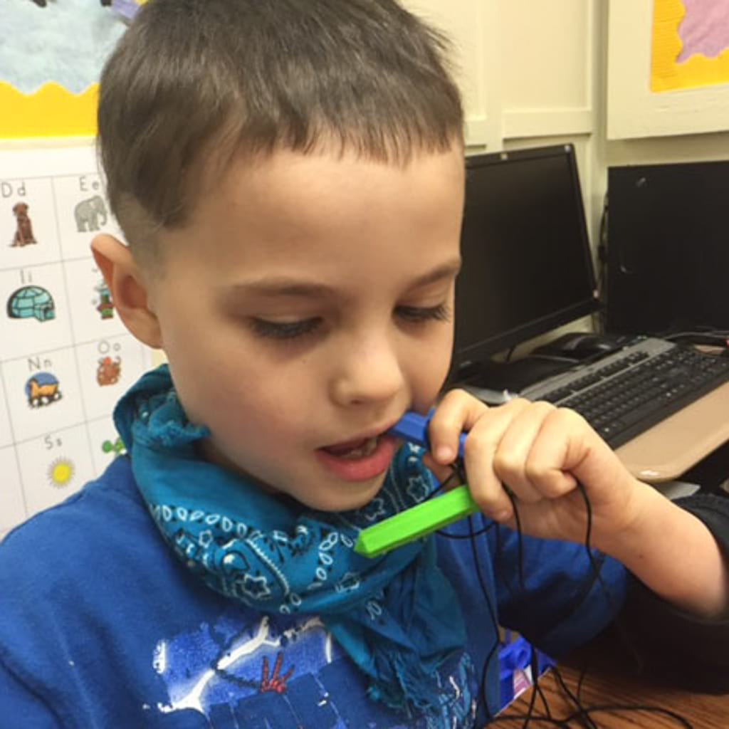 Boy with anxiety chewing on Ark's krypto bite sensory chew necklace Australia