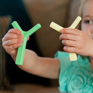 Caucasian girl holding Ark's Y shaped sensory toys in each hand in Australia