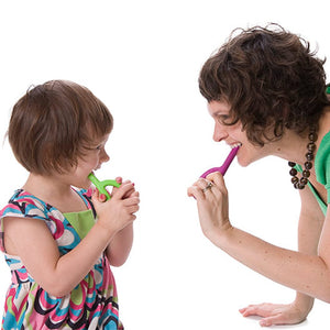 Mother and toddler daughter smiling while chewing on Ark's original oral motor sensory toys in lime green and magenta