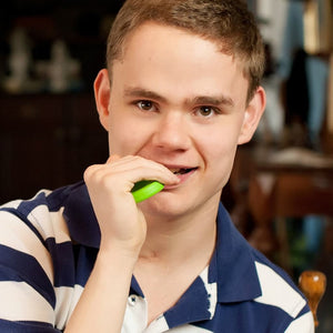 Caucasian teenager boy chewing on Ark's grabber the original motor chew tool as an alternative to grinding teeth