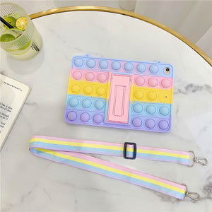 Fidget popper iPad case with shoulder strap in pastel colours on a marble table