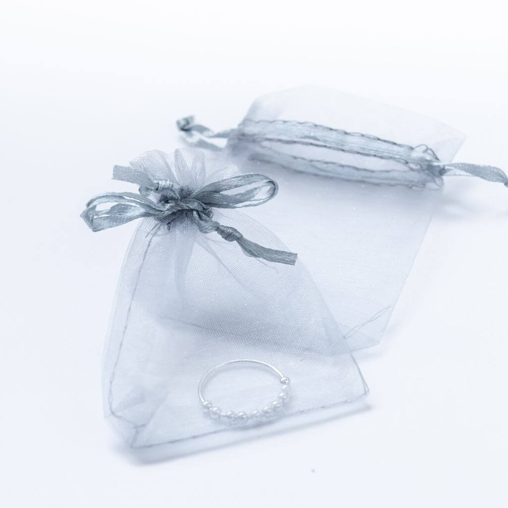 Fidget ring with beads made of sterling silver in a grey organza pouch