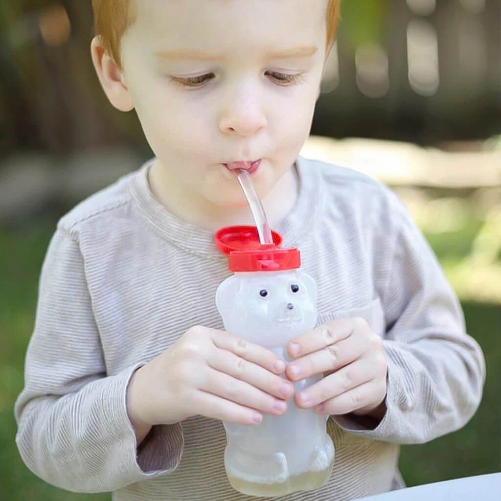 Cucasian boy sipping from a honey bear bottle Australia by Ark Therapeutic