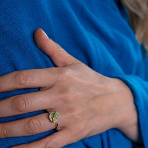 Woman wearing a planet spinner ring in gold blue shawl background