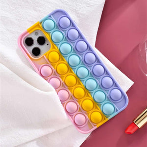 Pop it fidget phone case for iPhone in rainbow pastel colours on a white pink background and a red lipstick