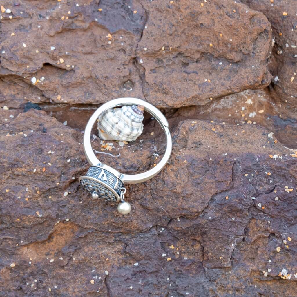 Sterling silver Buddhist Tibetan prayer wheel fidget ring Australia on brown stone background