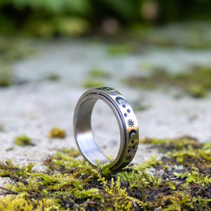 Sun moon and stars stainless steel silver anxiety ring on green moss