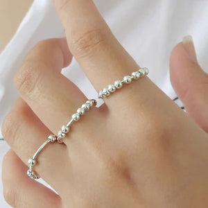 Woman wearing 3 sterling silver bead spinner rings
